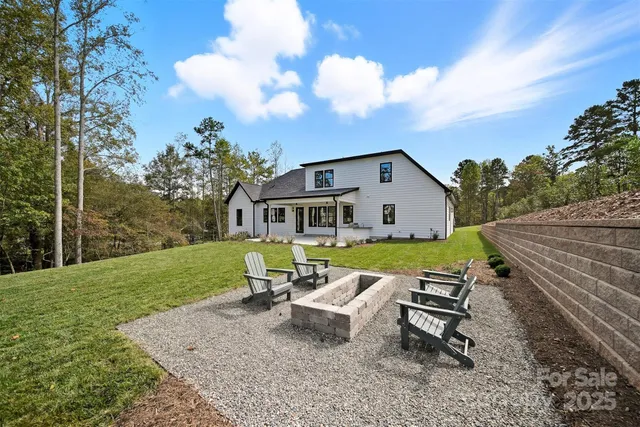 a view of a white house with a yard and sitting area