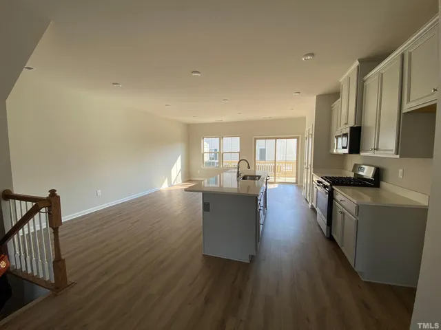 a view of a kitchen with wooden floor and electronic appliances