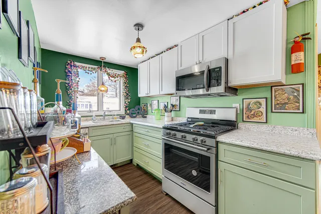 a kitchen with stainless steel appliances granite countertop a stove and cabinets