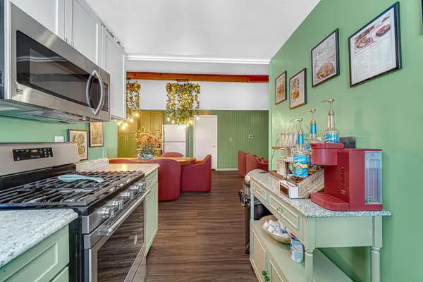 a kitchen with stainless steel appliances granite countertop a stove and a microwave
