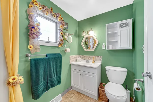 a bathroom with a toilet a sink and mirror