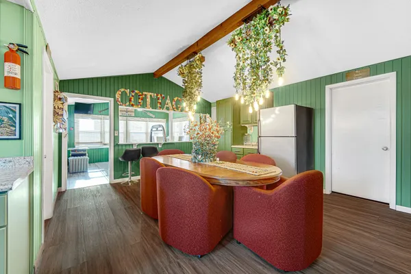 a dining room with furniture a kitchen view and wooden floor
