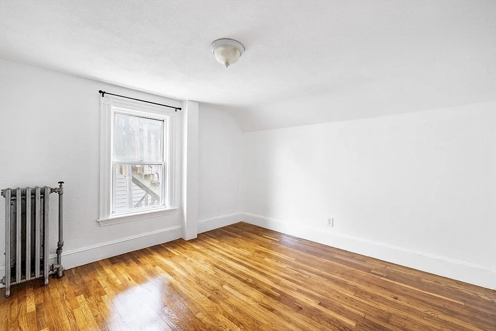 59-61 Glenwood Road, Unit 59 Somerville, MA 02145 - Photo 13 of 31 an empty room with wooden floor and windows