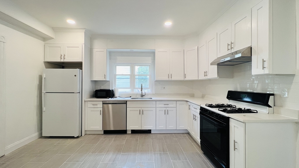 59-61 Glenwood Road, Unit 59 Somerville, MA 02145 - Photo 15 of 31 a kitchen with white cabinets and white appliances