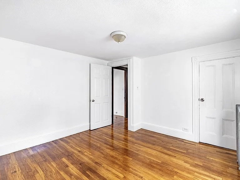 59-61 Glenwood Road, Unit 59 Somerville, MA 02145 - Photo 17 of 31 a view of an empty room with wooden floor and a window