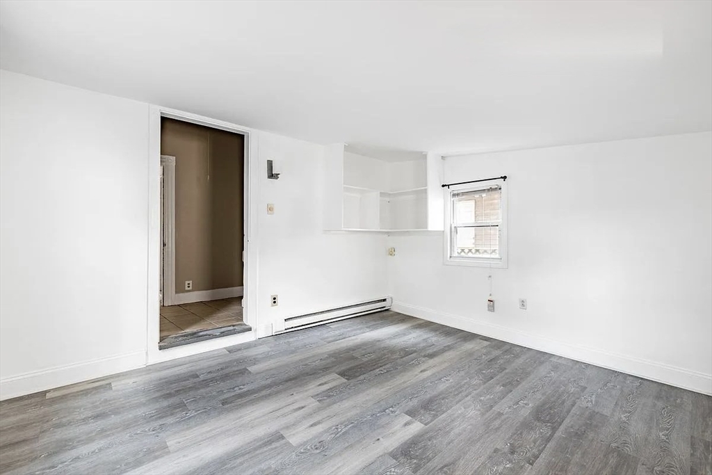 59-61 Glenwood Road, Unit 59 Somerville, MA 02145 - Photo 29 of 31 an empty room with wooden floor and windows