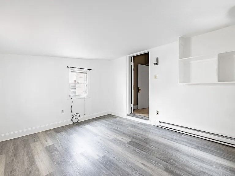 59-61 Glenwood Road, Unit 59 Somerville, MA 02145 - Photo 30 of 31 an empty room with wooden floor and windows