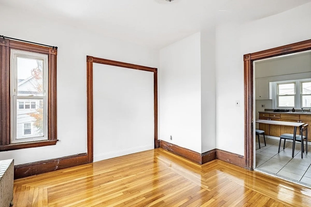 59-61 Glenwood Road, Unit 59 Somerville, MA 02145 - Photo 9 of 31 a view of room with window and wooden floor