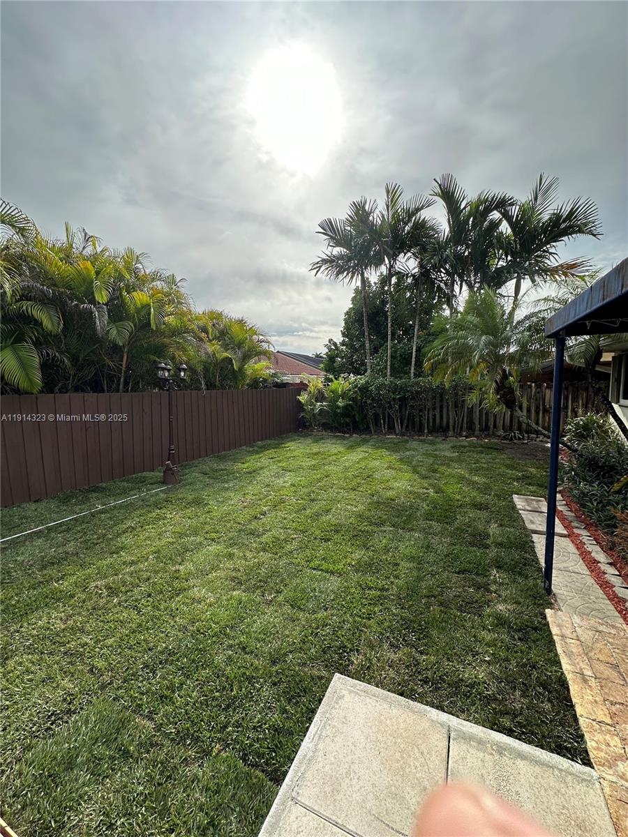 8035 Southwest 89th Court Miami, FL 33173 - Photo 27 of 31 a backyard with potted plants and palm trees