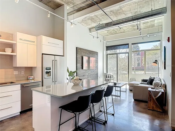 a dining hall with stainless steel appliances kitchen island granite countertop a dining table and chairs