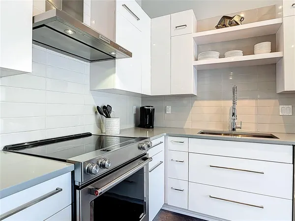a kitchen with granite countertop cabinets stainless steel appliances and wooden floor
