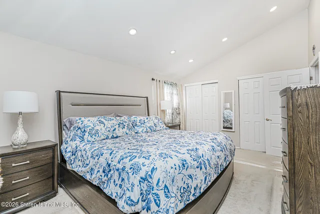 a bedroom with a large bed and a lamp