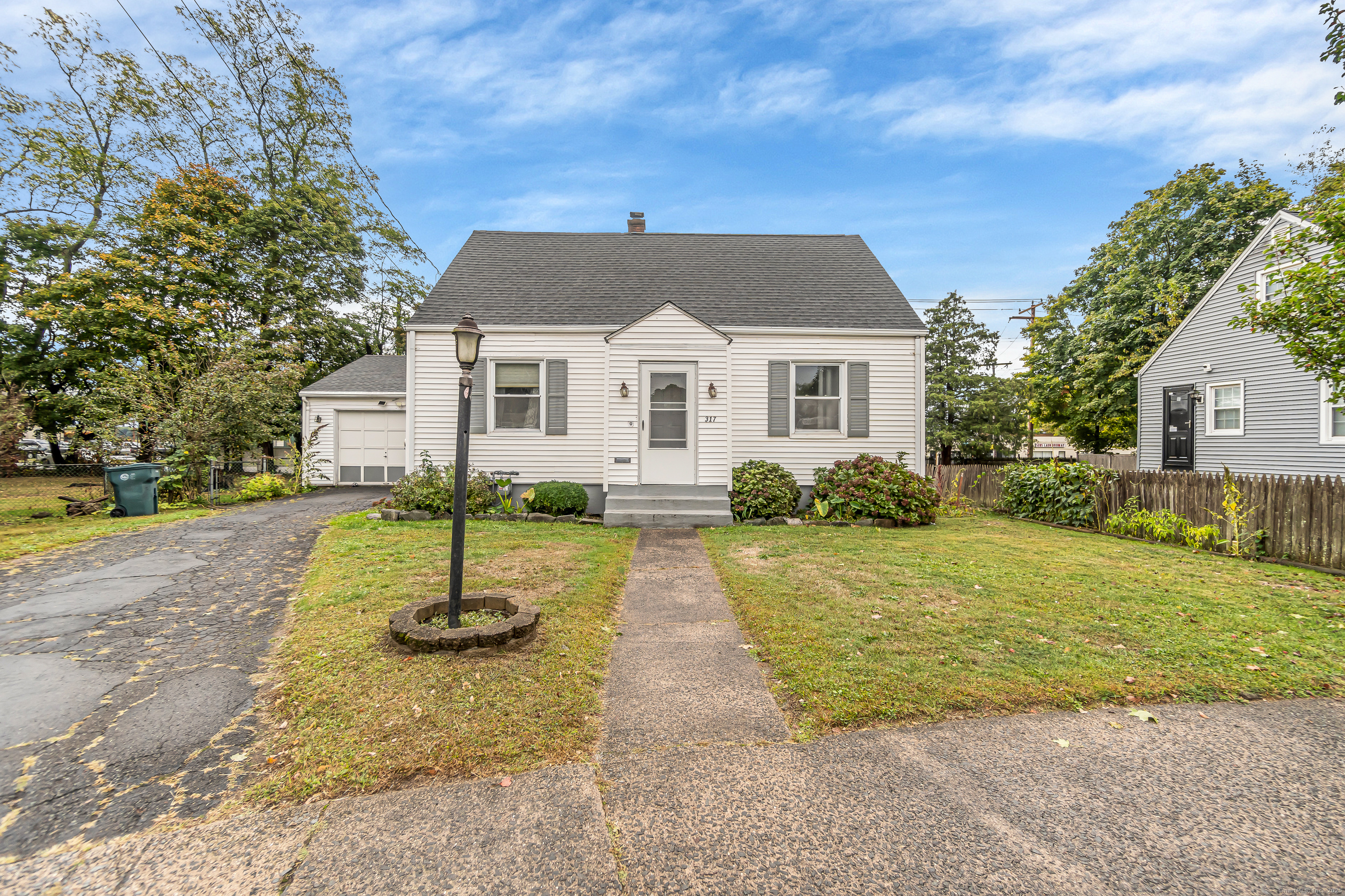 a front view of a house with a yard and trees