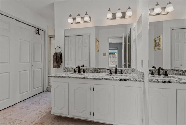 a bathroom with a double vanity sink and a mirror
