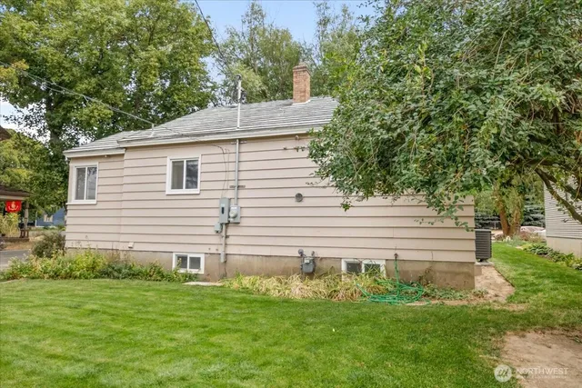 a front view of a house with a yard and trees