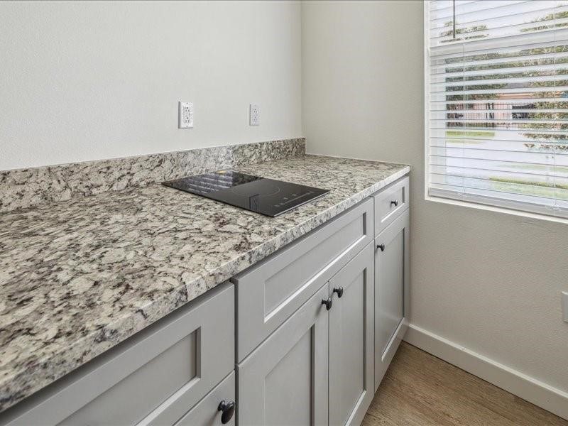 905 74th Street, Unit 1 Houston, TX 77011 - Photo 5 of 10 a utility room with granite countertop white cabinets and a sink
