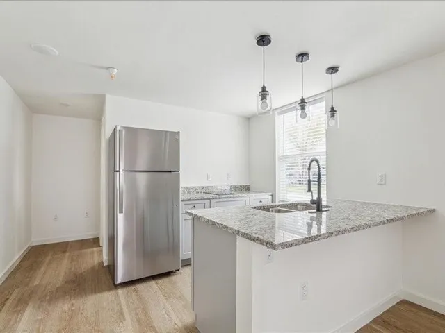 a kitchen with kitchen island a counter top space and refrigerator