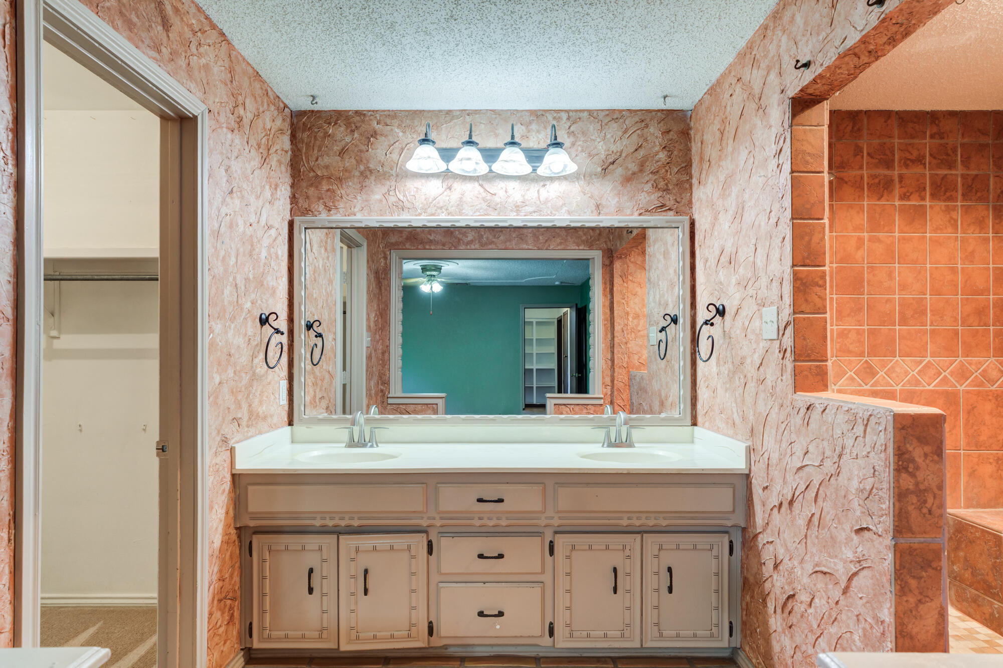 5523 74th Street Lubbock, TX 79424 - Photo 11 of 18 a bathroom with a double vanity sink and a mirror
