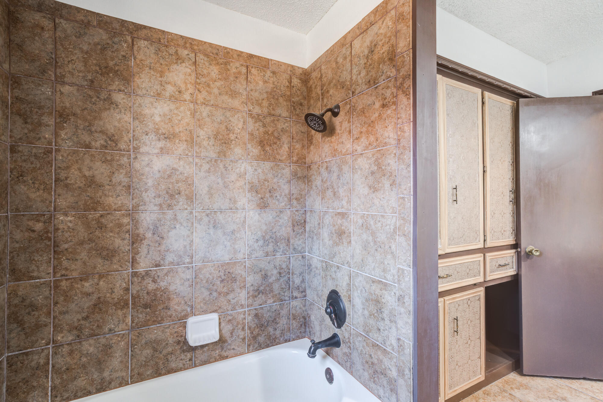 5523 74th Street Lubbock, TX 79424 - Photo 16 of 18 a bathroom with a bathtub and shower