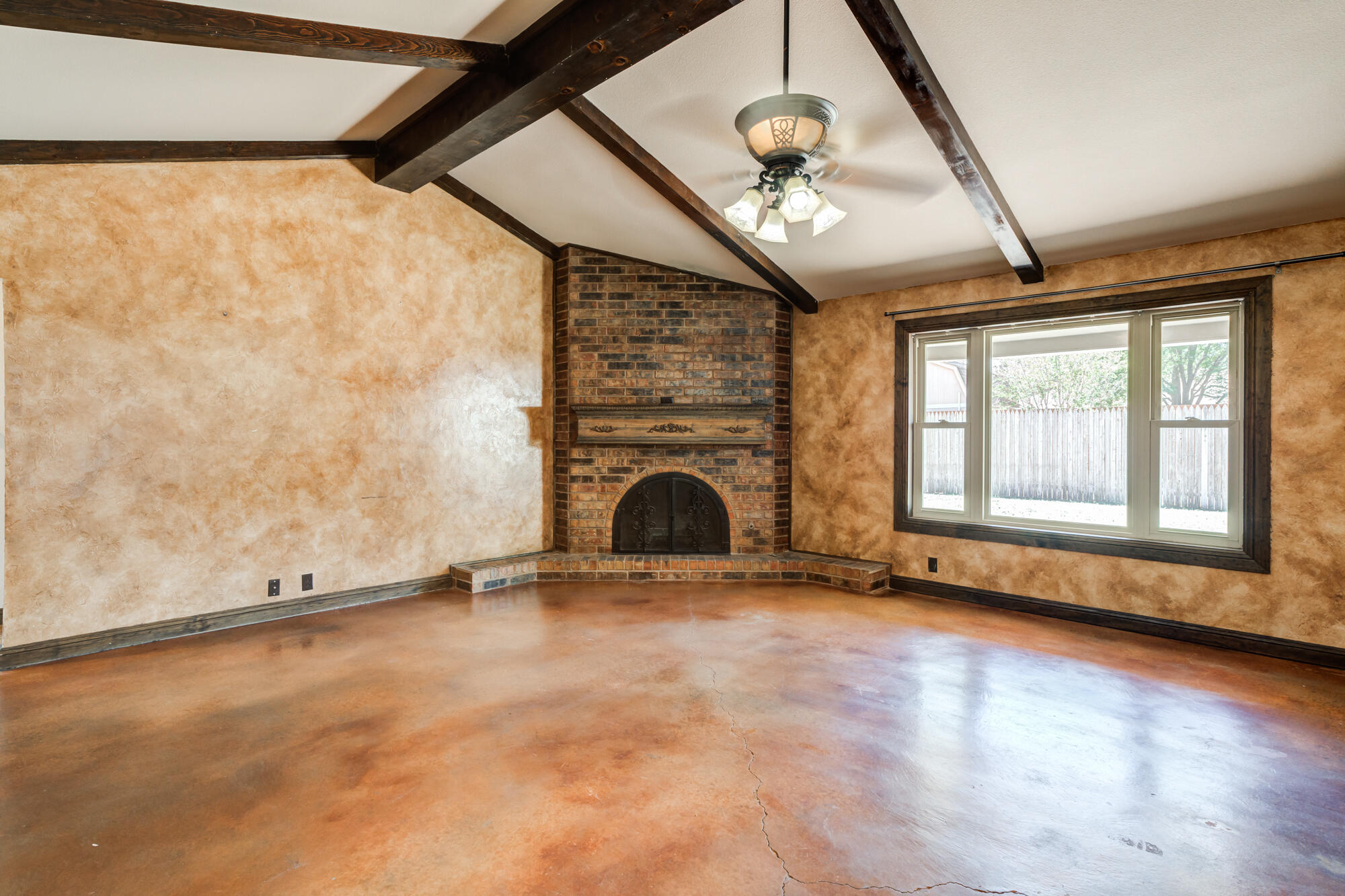 5523 74th Street Lubbock, TX 79424 - Photo 2 of 18 an empty room with windows and fireplace