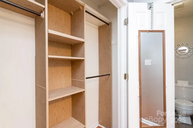 a view of walk in closet with empty racks