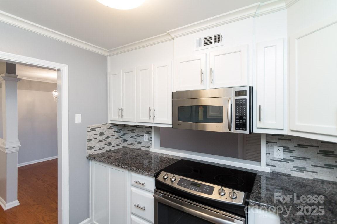 140 Lake Concord Road Northeast, Unit B4 Concord, NC 28025 - Photo 3 of 23 a kitchen with granite countertop a stove and a microwave
