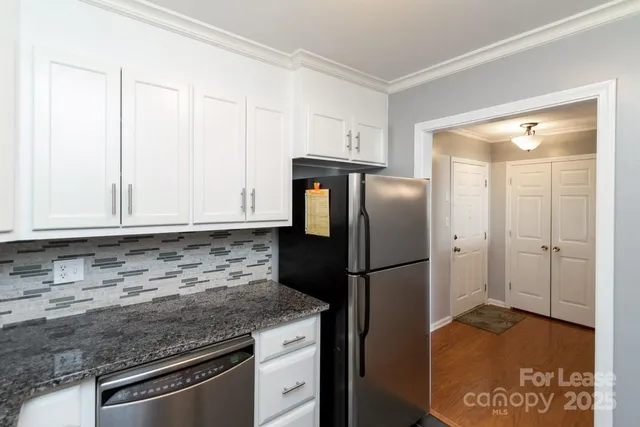a kitchen with granite countertop a refrigerator and a sink