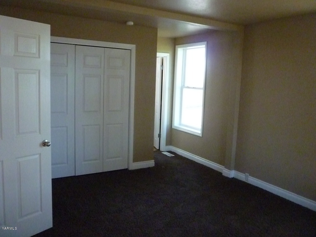 3020 Fort Road Toppenish, WA 98948 - Photo 18 of 37 an empty room with wooden floor and windows with curtains