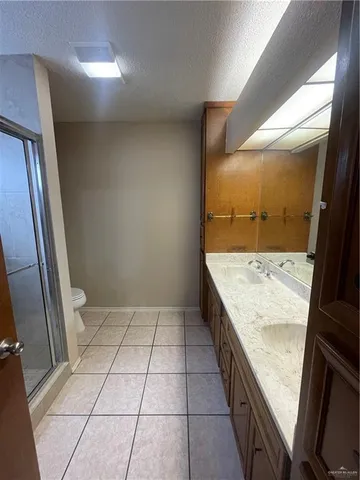 a bathroom with a granite countertop sink and a shower