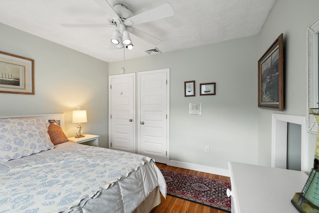 23 Oceanside Drive Scituate, MA 02066 - Photo 26 of 39 a bedroom with a bed and a chandelier