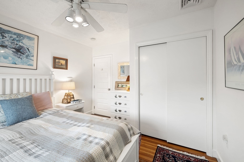 23 Oceanside Drive Scituate, MA 02066 - Photo 30 of 39 a bedroom with a bed and a chandelier