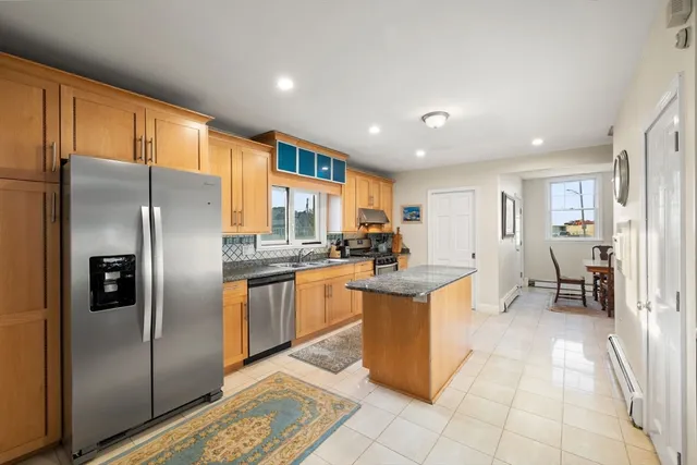 a kitchen with stainless steel appliances granite countertop a refrigerator and a stove top oven