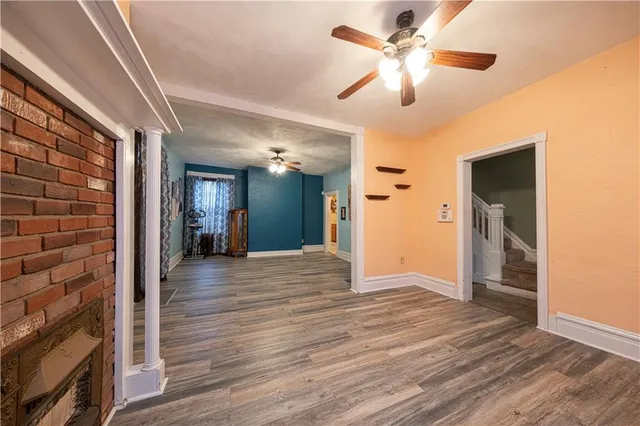 a view of a livingroom with a chandelier fan and a kitchen