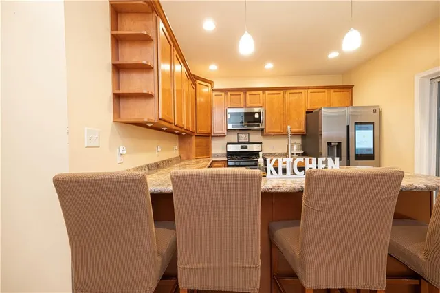 a living room with couches and kitchen view with wooden floor