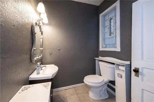 a bathroom with a toilet a sink and mirror