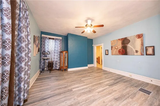 a view of an empty room with wooden floor