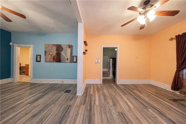 a view of a big room with wooden floor and a ceiling fan