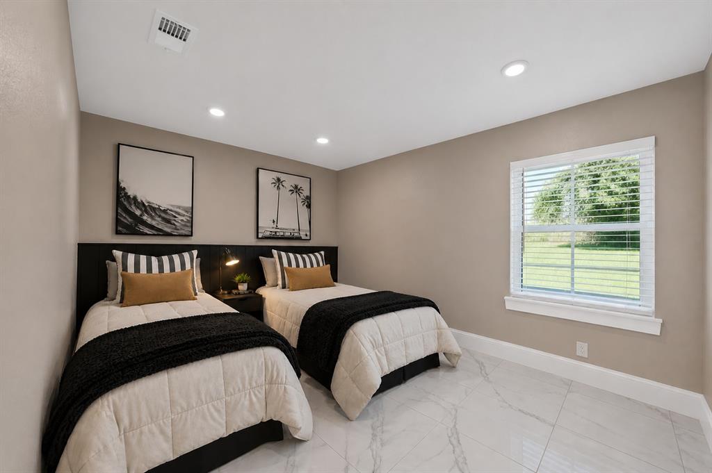 620 East 6th Street Springtown, TX 76082 - Photo 12 of 40 a bedroom with two beds and a window