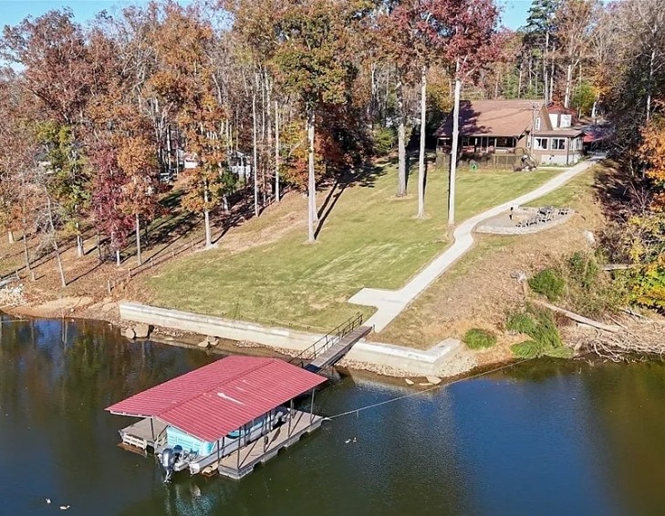 This scenic waterfront property offers a private boat dock and a charming residence nestled among mature trees.