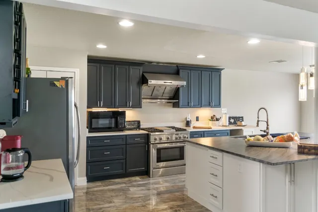 a kitchen with stainless steel appliances granite countertop a sink stove and refrigerator