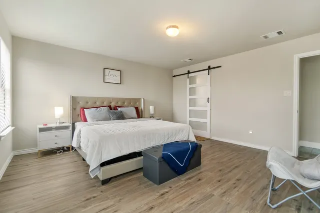 a bedroom with a bed and wooden floor