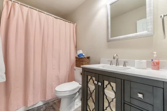 a bathroom with a sink a toilet and a mirror