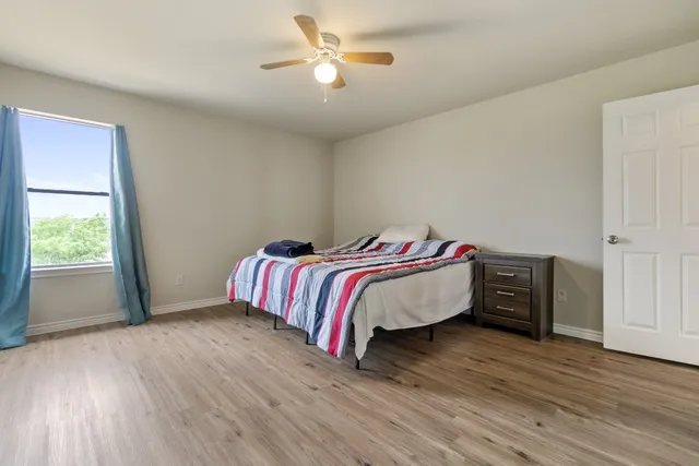 a bedroom with a bed and wooden floor