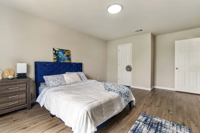 a bedroom with bed and wooden floor