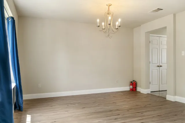 a view of a chandelier in big room and wooden floor