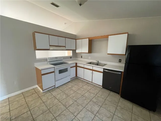 a kitchen with a sink a stove top oven and cabinetry