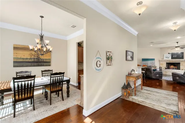 a view of a dining room with furniture a chandelier and wooden floor