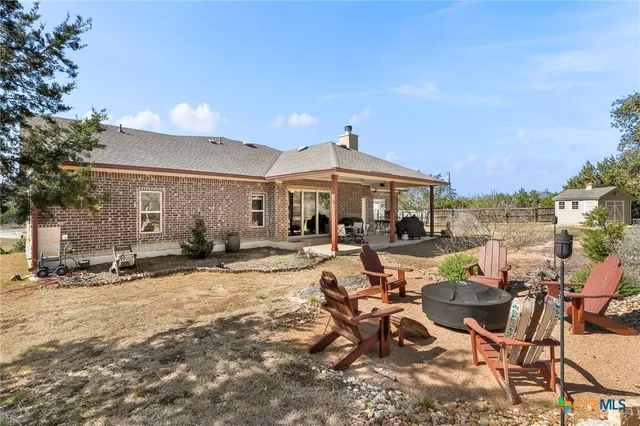 a view of a patio with table and chairs near a yard