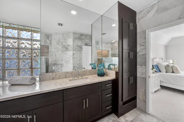a bathroom with a granite countertop sink a potted plant and a shower