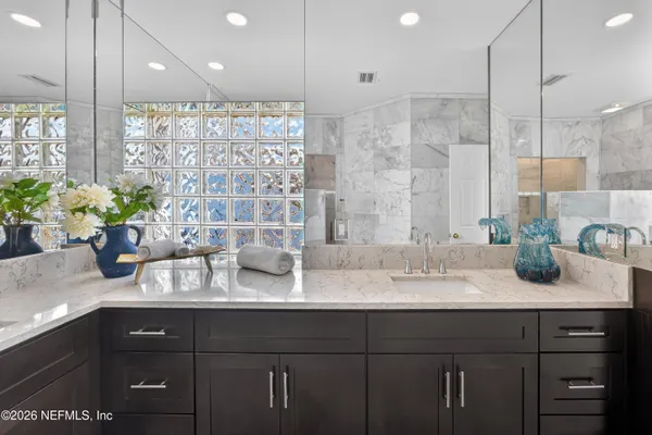 a bathroom with a double vanity sink mirror and shower